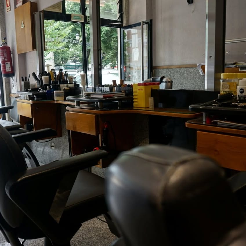 Interior da Barbearia Lagartos, com as cadeiras e as bancadas viradas para a montra